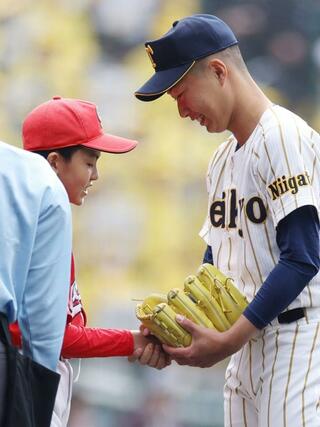 始球式を務めた子どもと握手する帝京長岡の先発工藤壱朗＝２３日、阪神甲子園球場