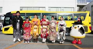 　「はとバス二十歳を祝う会」で、記念写真に納まる２０歳になるガイドの女性と整備士の男性＝６日午前、東京都大田区