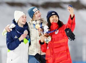 　女子個人ノーマルヒルで獲得した銅メダルを手に、金のストレム（中央）らと写真に納まる丸山希（右）＝プレダッツォ（共同）