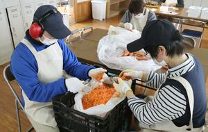 にじのそらでニンジンの皮むきに取り組む施設利用者=十日町市尾崎