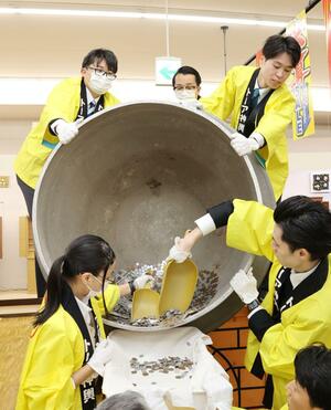 市民からの寄付が詰まった慈善釜の釜開け=12月23日、長岡市寺島町