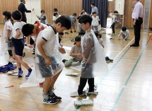 新聞紙のスリッパやビニール袋の防寒着の作り方を学んだ斐太北小の防災デー=妙高市飛田