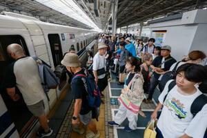 お盆のUターンラッシュで混雑するJR新大阪駅の新幹線ホーム=17日午前
