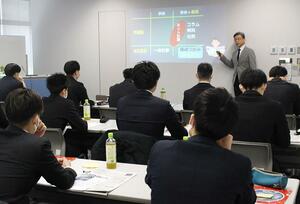 新聞記事を読みながらメディアリテラシーについて学ぶセコム上信越の新入社員=2日、新潟市中央区