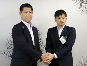 面会を終え、握手する三田市の田村克也市長(左)と上越市の中川幹太市長=22日、上越市役所
