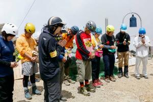 御嶽山山頂で黙とうする遺族ら=27日午前