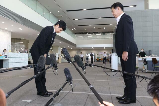 三田市の田村克也市長（右）に頭を上げる上越市の中川幹太市長＝２９日、兵庫県三田市の三田市役所