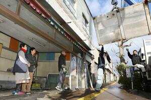 閉店した元助から運び出される冷蔵庫を見送る小竹正さん(左から2人目)と妻寿子さん(同1人目)=1月17日、新潟市西区内野町