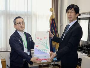 チューリップを受け取る住吉小学校の中野隆一校長(右)=新発田市住吉町3
