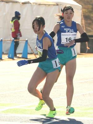 女子 十日町南の4区髙橋愛希生(右)がアンカーの阿部杏菜にたすきをつなぐ=滋賀県希望が丘文化公園