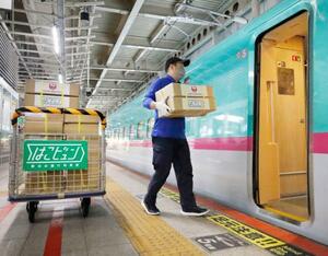 仙台駅で東北新幹線に積み込まれる、観光農園で生産されたナシを詰め込んだ段ボール箱=7日正午ごろ