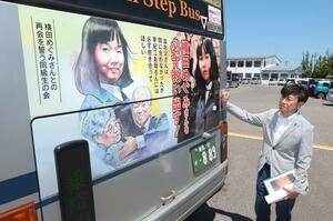 バスの車外後部に掲示された、横田めぐみさんと家族が抱き合うイラストなどが描かれた広告＝５日、新潟市西区