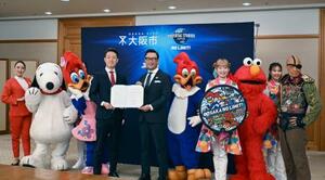 　包括連携協定の締結式で、記念写真に納まるＵＳＪと大阪市の関係者＝１２日午前、大阪市役所