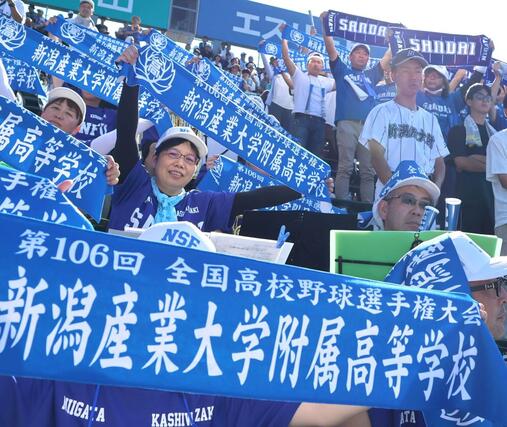 新潟刺繍が作ったグッズを手に力強い声援を送った新潟産大付属高校のスタンド＝甲子園