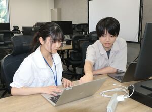 質問をしながら、パソコンを操作する学生(左)と、PRUM佐渡オフィスの社員=佐渡市秋津
