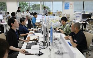 クールビズが始まり、ポロシャツなどの服装で仕事をする環境省の職員ら=5月1日、東京・霞が関