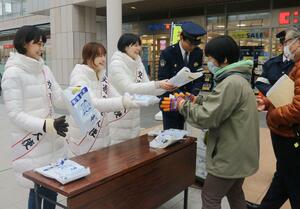 交通安全大使に任命され、チラシなどを手渡すNegiccoの3人=4日、新潟市中央区