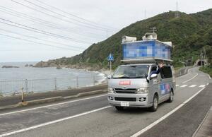 海沿いの県道を走る選挙カー。有権者からは離島の生活事情を踏まえて政策を進めてもらいたいとの声が上がる=10月16日、佐渡市相川地区