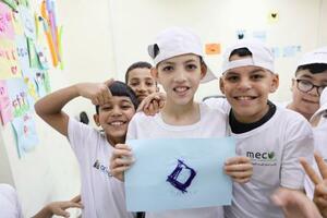 自分の作った作品を得意げに見せる子どもたち=7月、ヨルダン川西岸ファラ(共同)