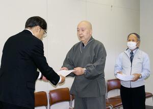 県の担当者に米坂線の早期復旧を訴える要望書を手渡す市民団体=新潟県庁