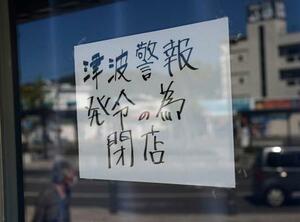 岩手県に津波警報が発令され、宮古駅前の売店に張られた臨時休業を知らせる張り紙=30日午後2時2分、岩手県宮古市