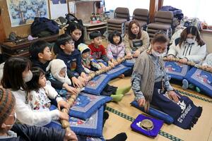 子どもたちが参加し、巨大な数珠を回した百万遍=2月23日、胎内市菅田