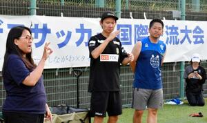 交流キャンプで手話を使いコミュニケーションを取るデフサッカー男子日本代表元監督の植松隼人さん(中央)=8月、東京都品川区