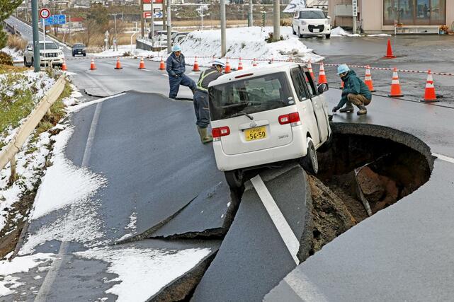 強い地震があった青森県東北町の陥没した道路で作業する人たち＝９日午後０時８分