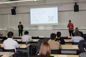 外国人雇用セミナーで、雇用実績を説明する佐渡精密の佐合一樹さん（右）＝佐渡市役所