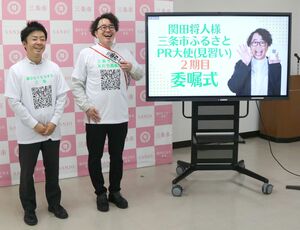 三条市のLINEのQRコードがプリントされたTシャツを着る関田将人さん(右)。左は滝沢亮市長=三条市役所