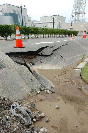 中越沖地震の揺れで崩れた原発構内の道路。左後方は６号機＝２００７年７月、柏崎刈羽原発