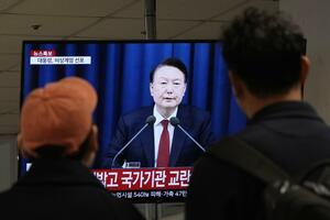 12月3日、ソウルのバスターミナルで、尹錫悦大統領の中継映像を見る人(AP=共同)