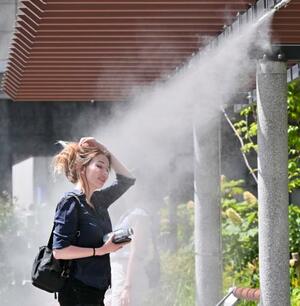 全国的に気温が上昇した28日、真夏のような暑さとなった東京・銀座でミストを浴び涼む女性