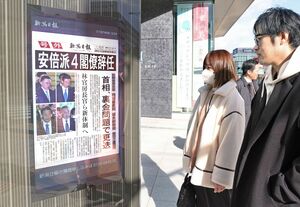安倍派4閣僚辞任の号外を眺める市民=2023年12月14日、新潟市中央区