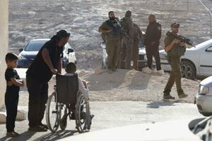 　イスラエルの入植者による銃撃で亡くなったパレスチナ人の追悼式会場周辺を警戒するイスラエル兵ら。式典参加者を尋問するなど緊迫感が漂う＝２０２５年９月、パレスチナ自治区ヨルダン川西岸マサフェルヤッタ（撮影・金子卓渡、共同）