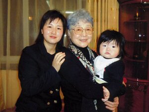キム・ウンギョンさん(左)の娘チオニちゃんを抱く横田早紀江さん=2014年3月、ウランバートル(有田芳生事務所提供)