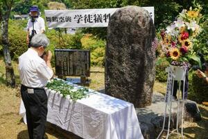 「舞鶴空襲」から80年となり、慰霊碑に手を合わせる参列者=29日午前、京都府舞鶴市