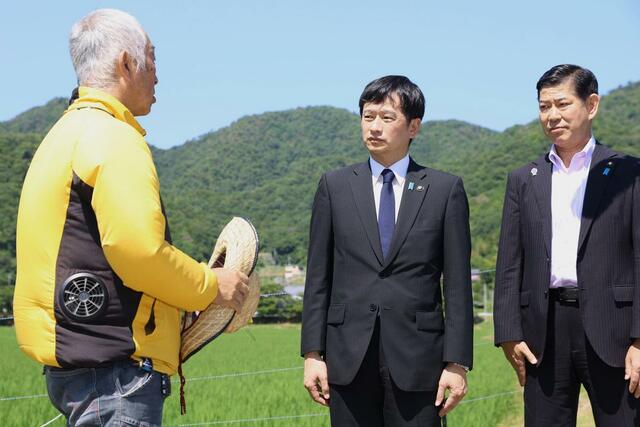 三田市の米農家を視察し、説明を受ける上越市の中川幹太市長（中央）＝２９日、兵庫県三田市