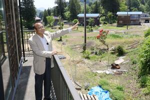 今冬の大雪を振り返る小川茂さん。自宅2階の手すり付近まで積雪があったという=長岡市山古志種苧原