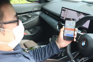 車内のスマートフォンで顧客からの配車通知を受け取るアプリを操作する、日本版ライドシェアのドライバー=6月7日、仙台市