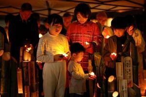熊本地震の「前震」から10年となり、発生時刻に黙とうする子どもら=14日午後9時26分、熊本県益城町
