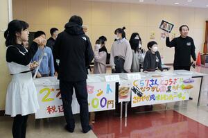 保護者に向けて、コラボ商品を販売する新津第一小の児童=新潟市秋葉区新津本町4