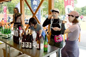 ゴール後に地酒を味わう越後謙信きき酒マラソンの参加者=2日、上越市