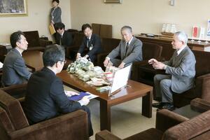 農業農村整備優良地区コンクールで農林水産大臣賞に選ばれ、鈴木康之副知事(左)に報告する糸魚川市大和川地区の関係者=3月27日、県庁