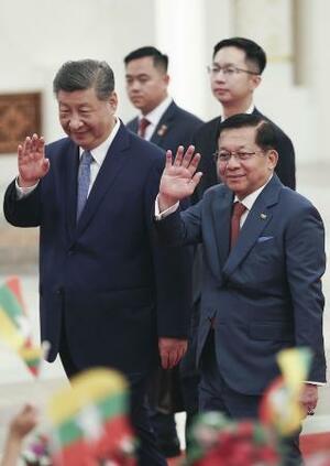 歓迎式典に臨む中国の習近平国家主席(手前左)とミャンマー親軍政権の大統領を務めるミンアウンフライン氏(同右)=16日、北京の人民大会堂(共同)