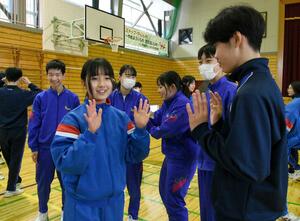3中学の生徒がバレーボールなどを楽しんだ交流授業。ハイタッチで交流を深めた=3月13日、上越市の浦川原中