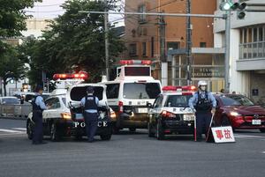 マイクロバスに歩行者がはねられた交差点を交通規制する警察官＝２９日午後７時７分、名古屋市南区