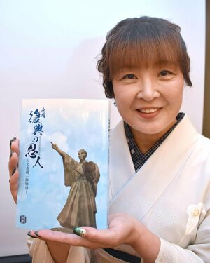 三島億二郎の足跡を分かりやすくつづった伝記を手にする著者の石坂智惠美さん=長岡市台町2