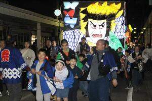 大きな万燈を引く子どもたち=佐渡市河原田本町