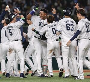 11回、サヨナラの悪送球を誘発する遊撃への内野安打を放ち、ナインに祝福される西武・セデーニョ(右から4人目)=ベルーナドーム